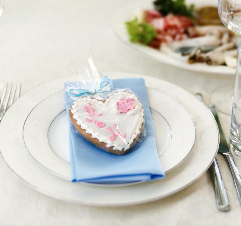 Gingerbread in form of heart lies on blue napkin on white dinner plate