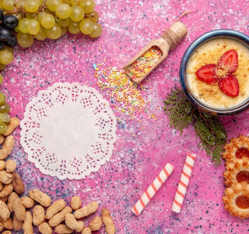 top view delicious creamy dessert with fresh grapes cookies crackers and peanuts on light pink background dessert ice-cream berry cream sweet fruit