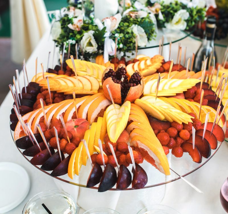 Plate with fruits, grapefruit, grapes, apple, pomegranate.
